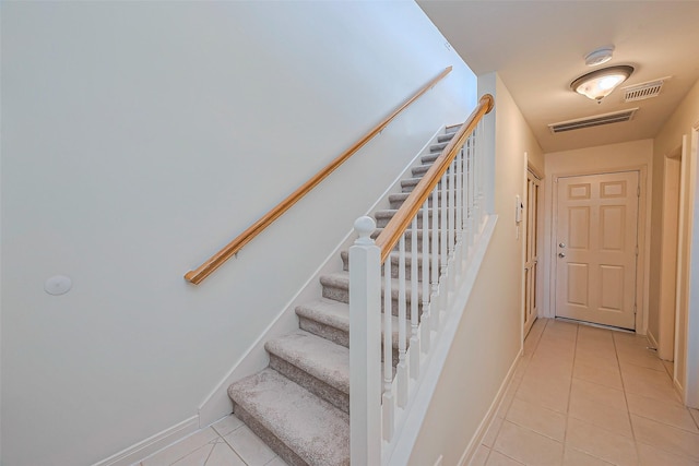 staircase with visible vents, baseboards, and tile patterned flooring