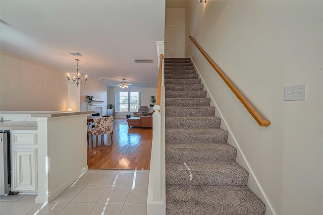 stairs with visible vents, a fireplace, and tile patterned flooring