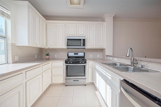 kitchen featuring crown molding, light tile patterned floors, decorative backsplash, appliances with stainless steel finishes, and a sink