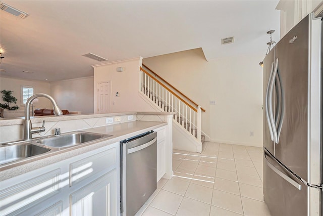 kitchen featuring visible vents, light countertops, light tile patterned floors, appliances with stainless steel finishes, and a sink