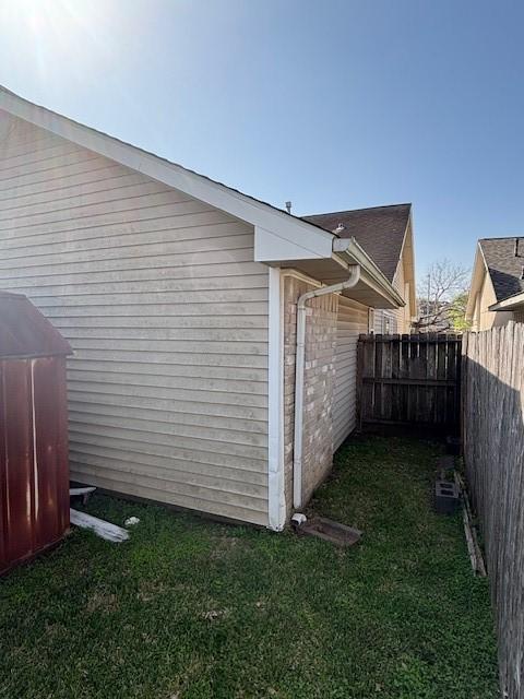 view of property exterior with a yard and fence