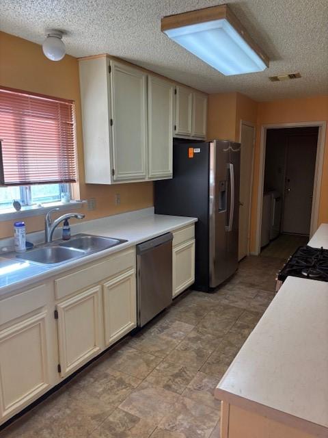 kitchen featuring a sink, visible vents, appliances with stainless steel finishes, and light countertops