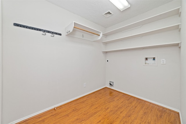 clothes washing area with electric dryer hookup, visible vents, wood finished floors, hookup for a washing machine, and laundry area