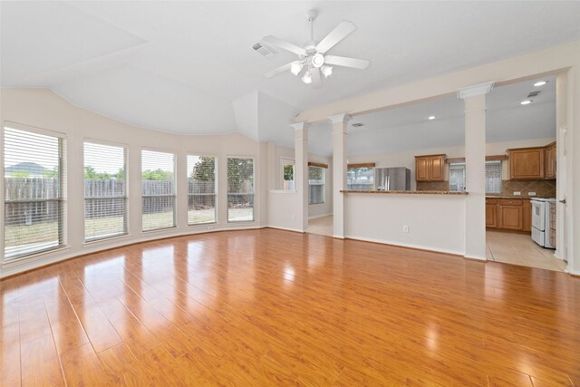 unfurnished living room featuring lofted ceiling, light wood-style flooring, decorative columns, and a ceiling fan