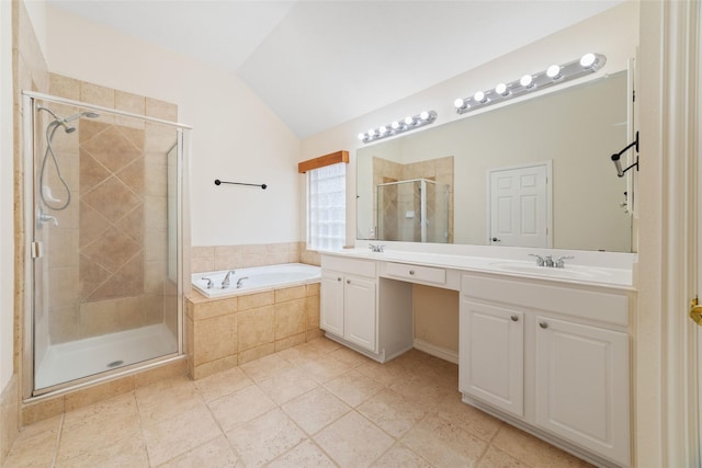 bathroom with a garden tub, a sink, a shower stall, double vanity, and vaulted ceiling