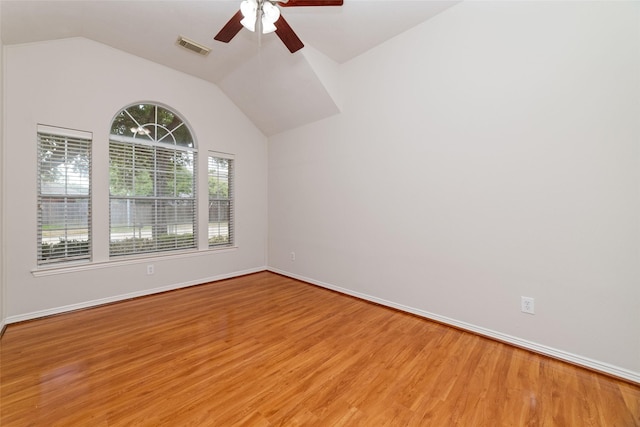 empty room with visible vents, baseboards, ceiling fan, vaulted ceiling, and light wood-style floors