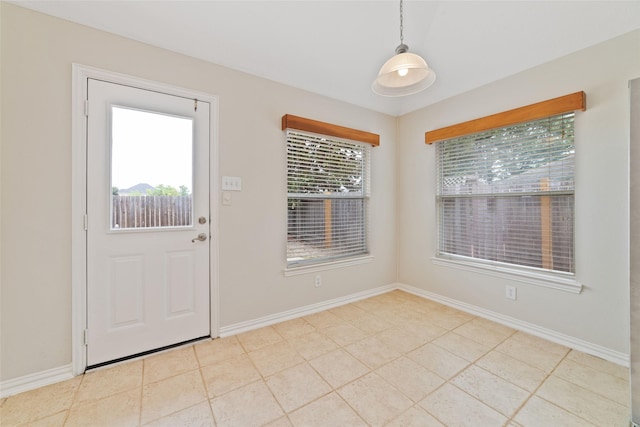interior space with baseboards and light tile patterned flooring