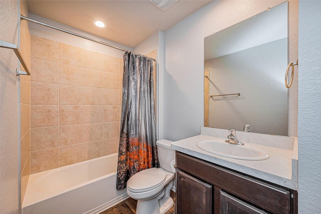 bathroom with vanity, toilet, a textured wall, and shower / bath combo with shower curtain