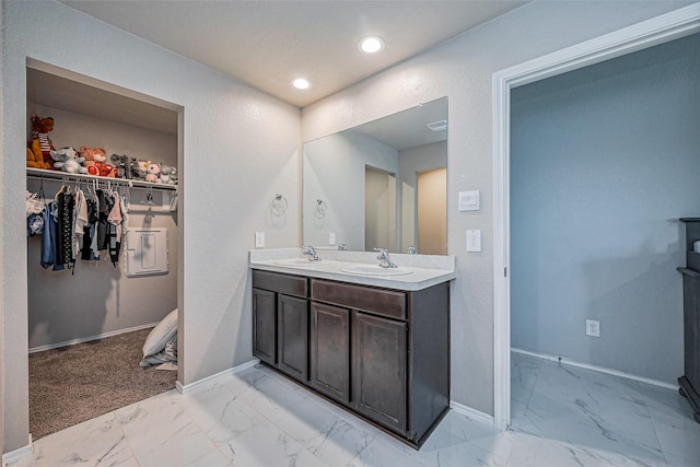 full bath featuring a sink, baseboards, and marble finish floor