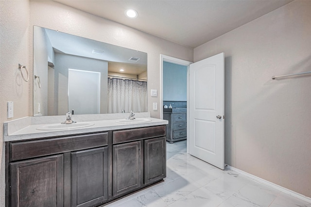 bathroom featuring visible vents, baseboards, double vanity, marble finish floor, and a sink