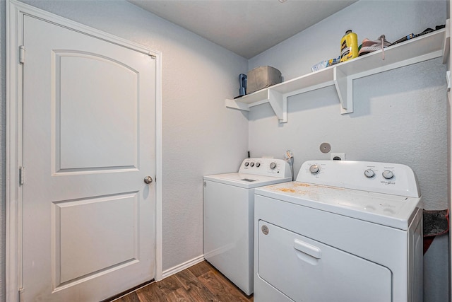 laundry area with laundry area, washing machine and dryer, and dark wood-style flooring