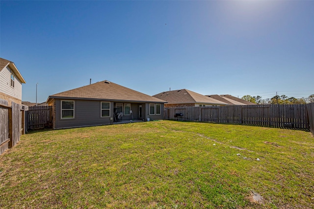 back of property featuring a lawn and a fenced backyard