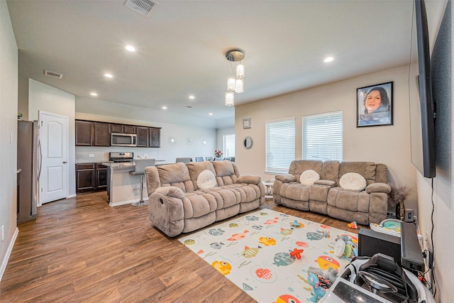 living room featuring visible vents, recessed lighting, and wood finished floors