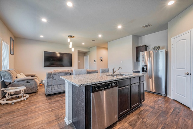 kitchen with visible vents, a sink, open floor plan, appliances with stainless steel finishes, and dark wood-style flooring