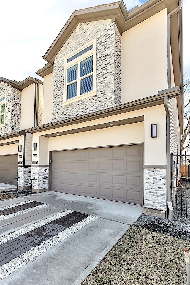 view of front facade featuring a garage, stone siding, driveway, and stucco siding