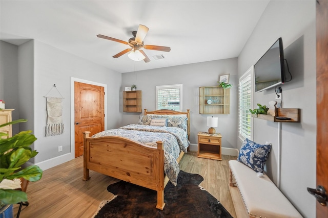 bedroom with visible vents, baseboards, light wood-style floors, and ceiling fan