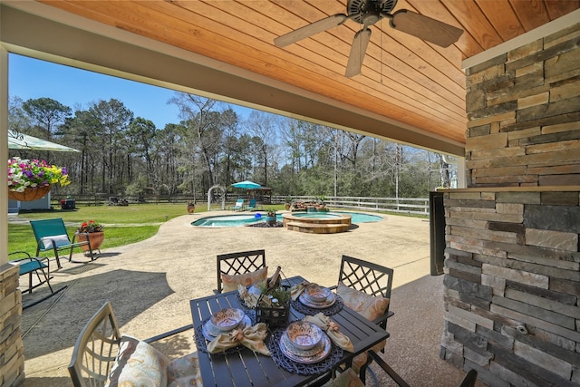 view of patio / terrace with outdoor dining space, a fenced backyard, a pool with connected hot tub, and ceiling fan