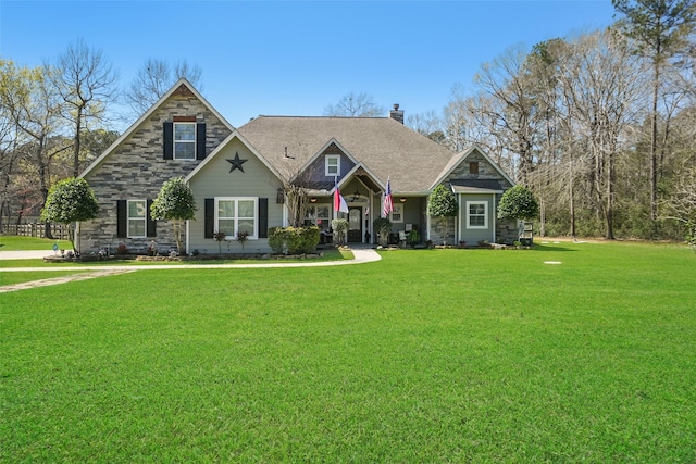 craftsman-style home with stone siding, a chimney, and a front lawn