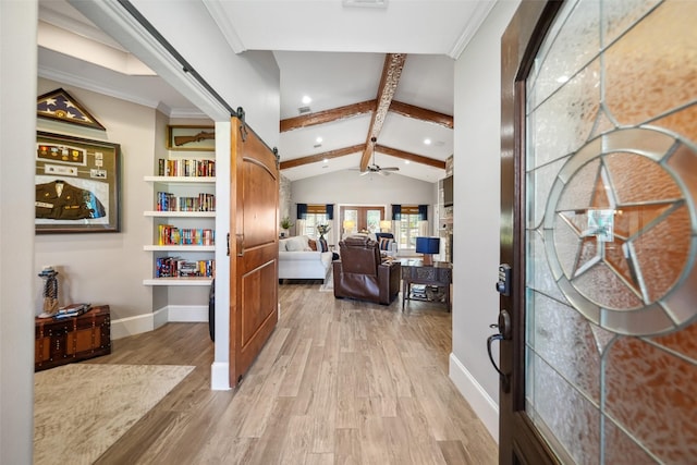 foyer with crown molding, baseboards, lofted ceiling with beams, a barn door, and light wood-style flooring