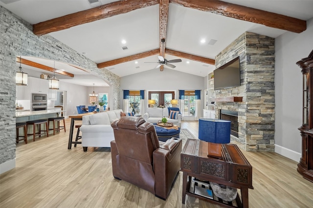 living room with light wood-type flooring, beamed ceiling, a fireplace, and visible vents