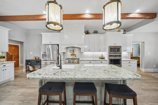 kitchen featuring backsplash, appliances with stainless steel finishes, and white cabinets