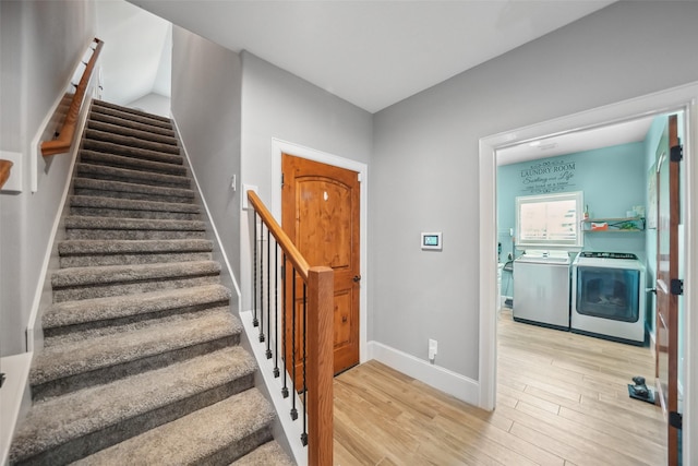 stairs featuring baseboards, wood finished floors, and washer and clothes dryer