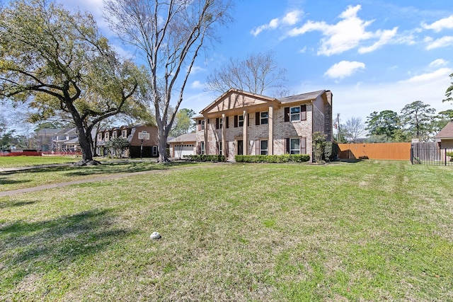 neoclassical / greek revival house with brick siding, a garage, a front yard, and fence