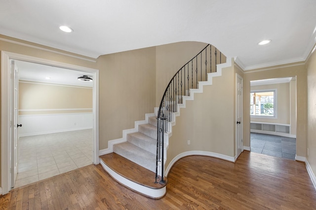 staircase with recessed lighting, wood finished floors, baseboards, and ornamental molding