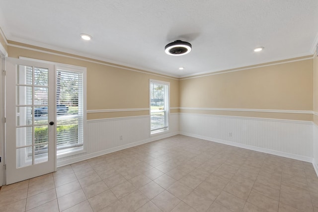 unfurnished room with a wainscoted wall, recessed lighting, and ornamental molding