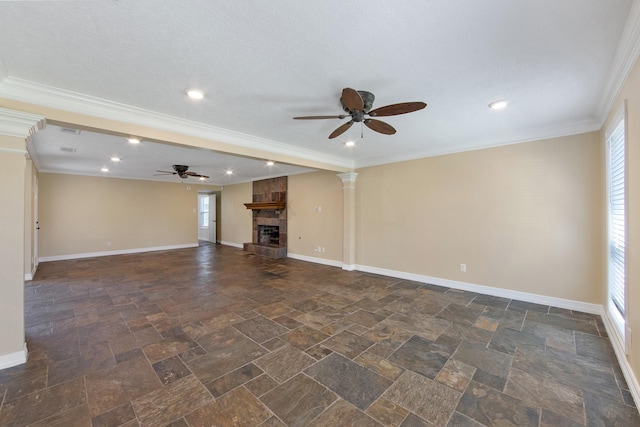 unfurnished living room with a stone fireplace, a healthy amount of sunlight, crown molding, and baseboards