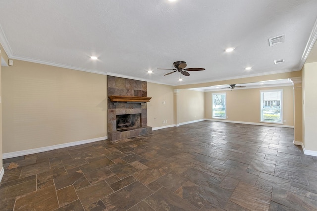 unfurnished living room with visible vents, baseboards, ornamental molding, a tile fireplace, and stone tile flooring