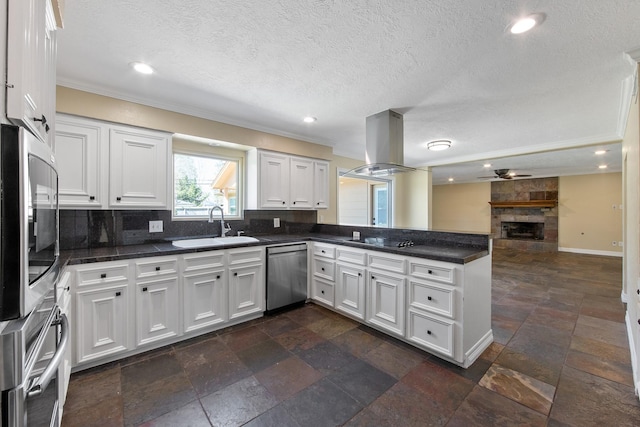 kitchen with a sink, open floor plan, appliances with stainless steel finishes, a peninsula, and island range hood