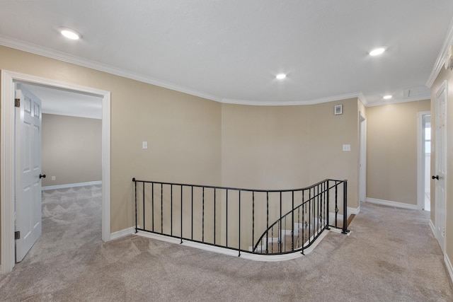 hall featuring an upstairs landing, ornamental molding, carpet, baseboards, and attic access