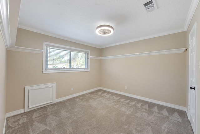 carpeted empty room with visible vents, a textured ceiling, crown molding, and baseboards