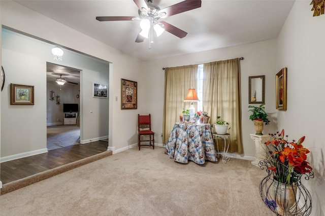 sitting room with a ceiling fan, baseboards, and carpet floors