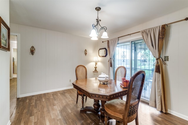 dining area with an inviting chandelier, wood finished floors, and baseboards