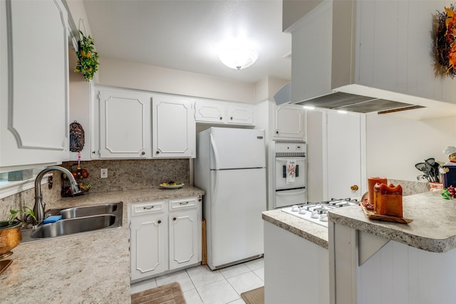 kitchen featuring white appliances, white cabinetry, wall chimney exhaust hood, and a sink