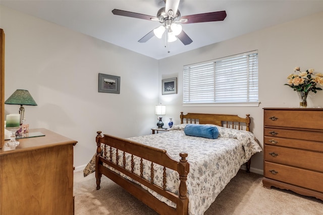 bedroom with light carpet, ceiling fan, and baseboards