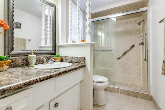 bathroom with vanity, toilet, a shower stall, and tile patterned flooring