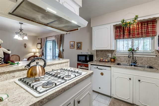 kitchen featuring stainless steel gas cooktop, white dishwasher, a sink, under cabinet range hood, and black microwave