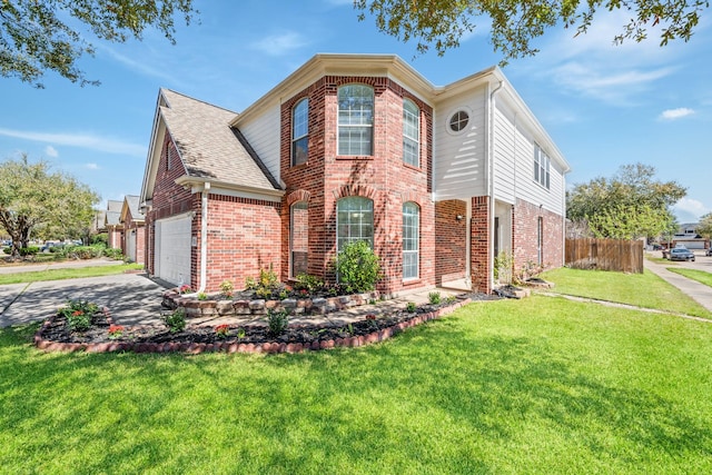 traditional home featuring a front yard, fence, driveway, a garage, and brick siding