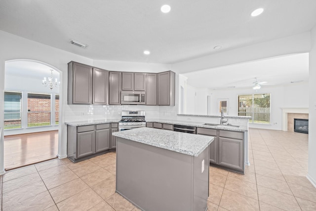 kitchen with visible vents, gray cabinetry, a sink, stainless steel appliances, and a peninsula