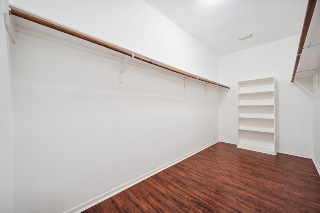 walk in closet featuring dark wood finished floors