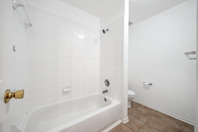 full bathroom featuring tile patterned floors, toilet, a textured ceiling, baseboards, and bathing tub / shower combination