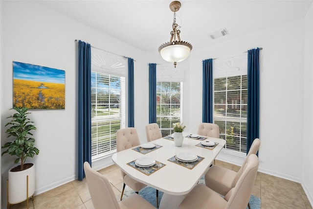 dining space with light tile patterned floors, visible vents, and baseboards