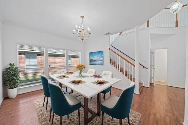 dining area featuring visible vents, crown molding, stairs, and wood finished floors