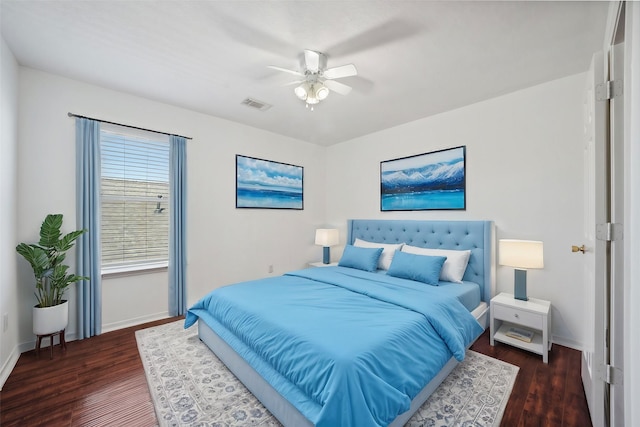 bedroom with ceiling fan, visible vents, baseboards, and wood finished floors