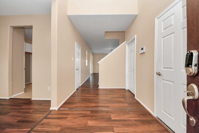 hallway featuring baseboards and wood finished floors