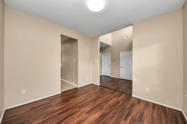 unfurnished room featuring visible vents, baseboards, and wood finished floors