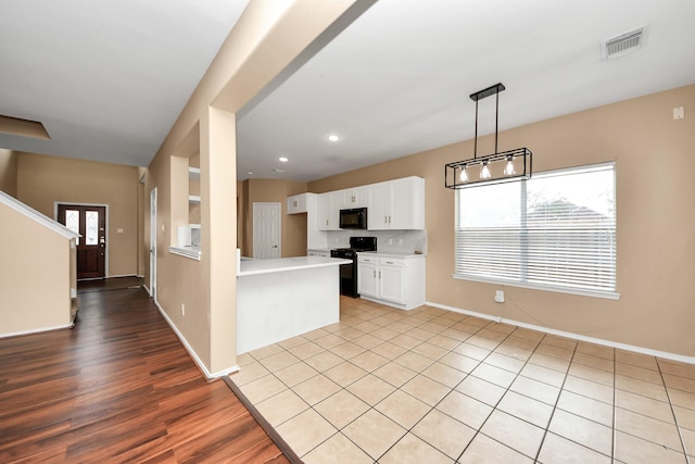 kitchen with visible vents, black appliances, white cabinets, light countertops, and a healthy amount of sunlight